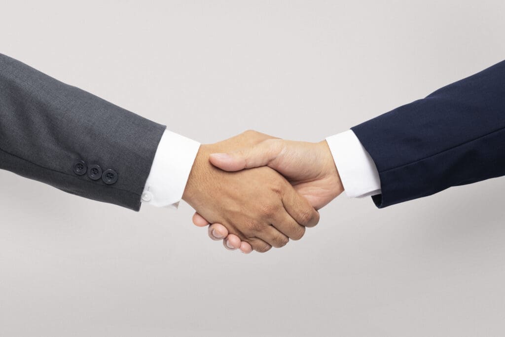 Two people in suits shaking hands to denote the business partnership. Effective Strategies for Performance Marketing, blog Wonkrew